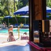 Piscina esterna con ombrelloni blu e macchina da caffè in primo piano.