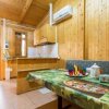 Interno in legno con tavolo apparecchiato, cucina e condizionatore.