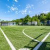 Campo da calcio recintato con cielo sereno sopra.