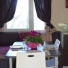 Cucina con tavolo apparecchiato, lampada e pianta viola al centro.