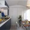 Cucina moderna con tavolo apparecchiato. Vista di un piano cottura e una pianta decorativa.