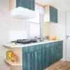 Cucina moderna con mobili verdi e pavimento in legno.