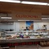 Banco gastronomia con salumi e vini esposti.