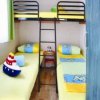 Una cameretta con due letti singoli e un letto a castello, pareti colorate e decorazioni marine.