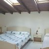 Stanza con letto matrimoniale e singolo sotto un soffitto di legno.