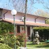 Un edificio con tetto rossiccio circondato da alberi e cespugli.