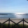 Vista sul mare con un camper e una spiaggia sabbiosa.