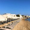 Ombrelloni chiari su una spiaggia sabbiosa vicino al mare.
