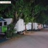 Viale di un campeggio di notte, illuminato e fiancheggiato da camper.