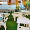 Patio coperto con tavoli e sedie in plastica.