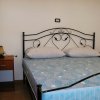Camera da letto con letto matrimoniale, testiera in ferro battuto e comodini.