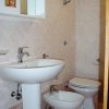 Bagno con lavabo, bidet, wc e piastrelle chiare.