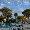 Piscina all'aperto con sedie a sdraio e alberi.