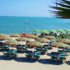 Una spiaggia con lettini e ombrelloni colorati.