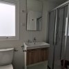 Bagno moderno con finestra opaca, lavabo, specchio, doccia e wc.