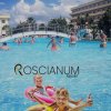 Persone nuotano in piscina con ponte.