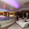 Piscina interna con lettini bianchi.