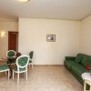 Sala con divano verde, tavolo rotondo e sedie abbinate.