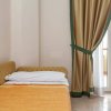 Letto singolo con coperta arancione, tende dorate.