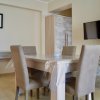 Sala da pranzo con tavolo quadrato e televisore.