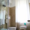 Bagno moderno con doccia in vetro, vaso, bidet e finestra.