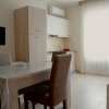 Sala da pranzo con tavolo, sedie e angolo cottura.
