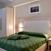 Camera con letto matrimoniale verde e armadio chiaro.