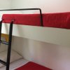 Letto a castello con lenzuola rosse.