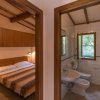 Vista su camera da letto e bagno, entrambi con finestra aperta e finiture in legno.