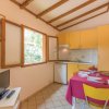 Cucina gialla con tavolo apparecchiato, finestra aperta e TV.