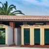 Edificio con tetto in tegole e cabine con porte verdi.