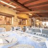 Interno di ristorante con tavoli apparecchiati, mattoni a vista e travi di legno.