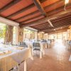 Sala ristorante con tavoli apparecchiati, travi a vista e ampie finestre.
