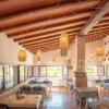 Interno di un ristorante luminoso con soffitto in legno, lanterne e tavoli apparecchiati.