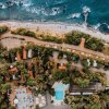 Vista dall'alto di un campeggio, strada, piscina e spiaggia adiacente.