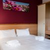 Camera da letto con pareti rosse, letto matrimoniale e lampada da comodino.