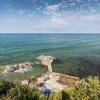 Scogliera con piccola piattaforma e mare calmo all'orizzonte.