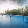 Due persone giocano a calcio su un campo sportivo blu all'aperto al tramonto.