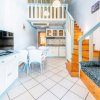 Interno moderno con soggiorno, cucina e soppalco. Arredamento bianco e azzurro.