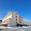 Edificio rosa invernale con neve e cielo blu.