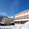 Hotel rosa tra neve e montagne innevate.