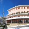 Edificio rosa con neve, cielo blu.