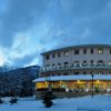 Edificio illuminato con neve, cielo scuro.