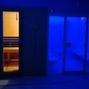 Ingresso sauna illuminato, stanza turchese accanto.