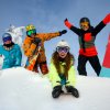 Persone felici sulla neve con attrezzatura da sci.