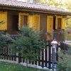Chalet in legno con finestre gialle e alberi attorno.