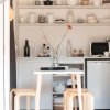 Tavolo bianco con sedie in legno chiaro in una cucina moderna e minimalista.