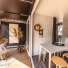 Interno moderno con tavolo, sedie e veranda aperta con poltrona intrecciata.