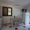 Cucina luminosa con tavolo da pranzo, frigorifero e accesso esterno.