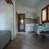 Cucina con tavolo, letto sulla sinistra e porta che conduce a un bagno.
